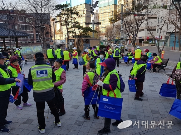 파란 다목적 백을 들고 거리로 향하는 환경지킴이 어르신들